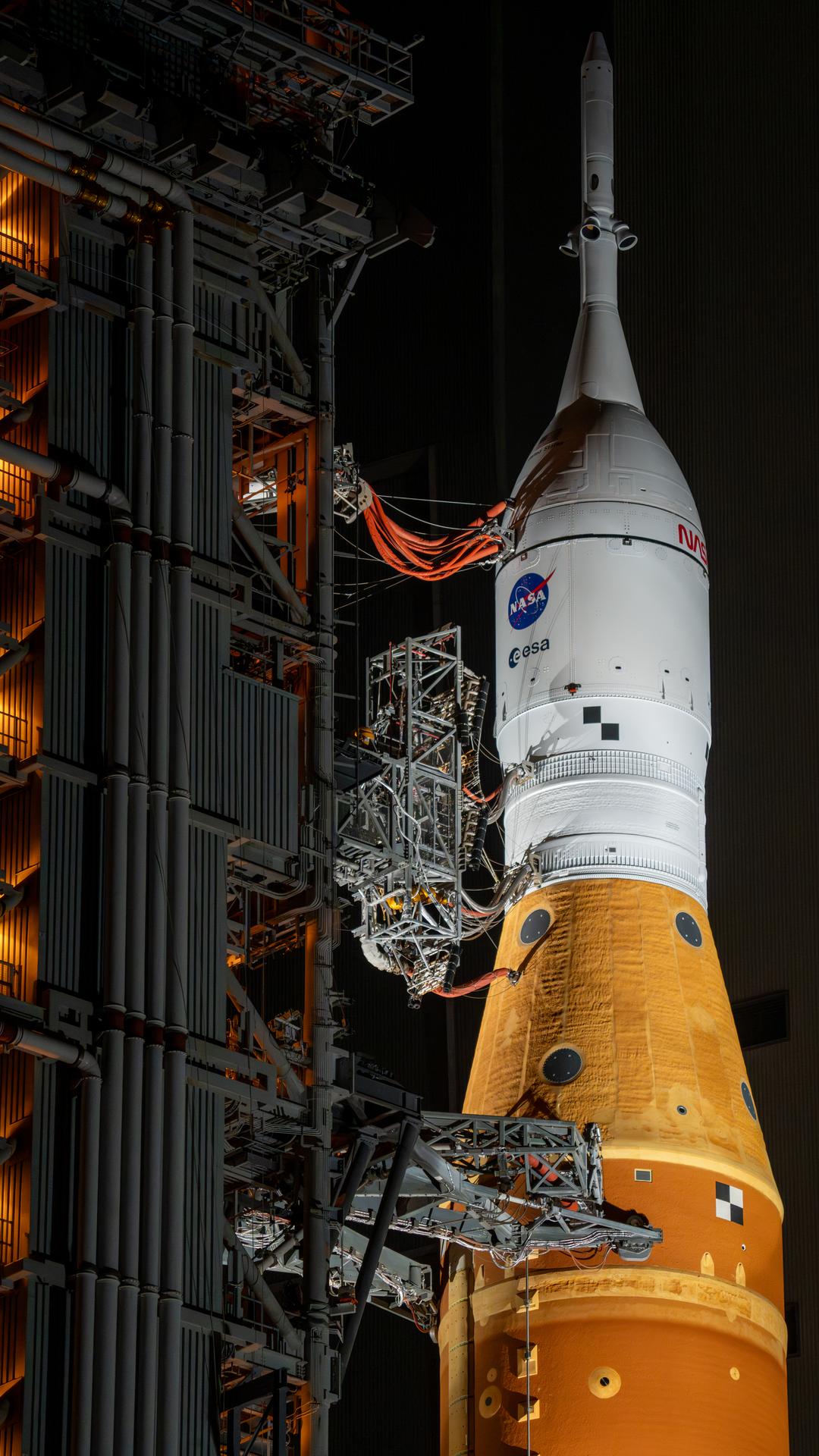 This image shows NASA’s SLS (Space Launch System) and Orion spacecraft rolling out of the Vehicle Assembly Building at NASA’s Kennedy Space Center. NASA's massive Crawler-Transporter, upgraded for the Artemis program, carries the powerful SLS rocket and Orion spacecraft on the Mobile Launcher from the Vehicle Assembly Building to Launch Pad 39B at Kennedy Space Center in preparation for the Artemis II mission. 